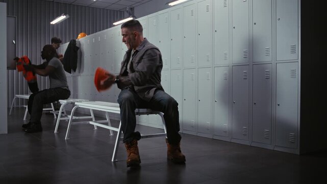 Diverse Industrial Workers Finish Tying Boots and Putting on Gear, Then Leave Modern Locker Room, Ready For Work Day, Leaving Behind Empty Facility Staff Room. Concept of End of Preparation Routine.