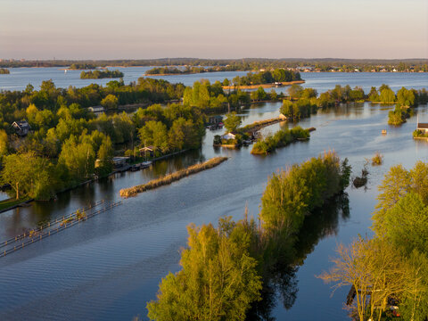 Breukelen, Netherlands - 25 April 2026: Aerial view of Scheendijk featuring narrow strips of land and small islands with lush green trees and summer houses on the Loosdrechtse Plassen.
