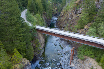 Rustic Bridge Over Rocky River Canyon Surrounded by Evergreen Forest in British Columbia, Canada © edb3_16
