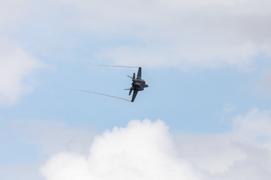 American 5th generation stealth fighter jet of the US Air Force performing aerial maneuvers in cloudy skies. Powerful modern military aircraft flying during aviation demonstration