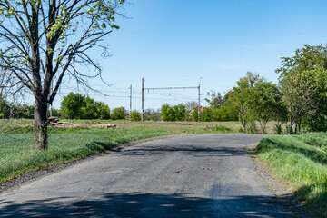 Naklejka premium Rural road with railway infrastructure and green landscape in village railway station Vrbatky, Czech Republic - May 3, 2026 Zeleznicni stanice, vlakova zastavka Nadrazi