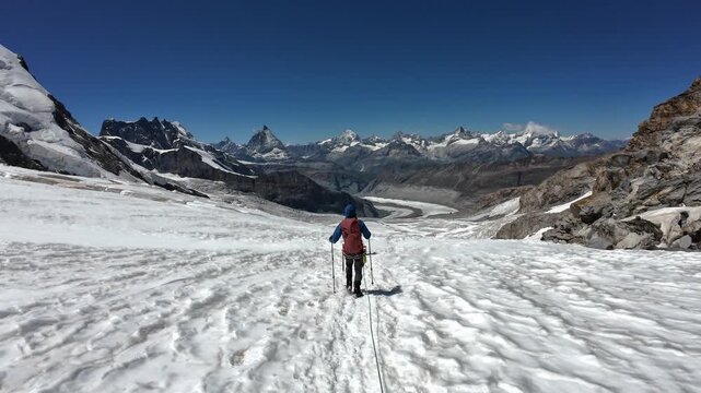 POV mountaineering in rope team on glacier Grenzgletscher and mountain panorama with summits Breithorn, Matterhorn, Dent Blanche, Zinalrothorn and Weisshorn in Pennine Alps, Switzerland