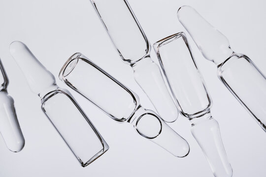 Transparent glass ampoules and vials symbolizing medical science and pharmaceutical research