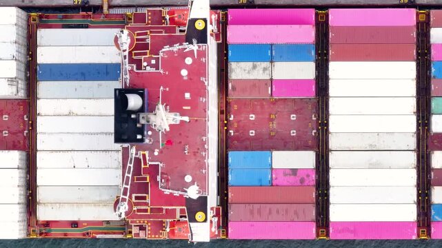 Colorful shipping containers line the decks of a large container ship as it docks at a busy cargo terminal. This glimpse into maritime logistics highlights essential global trade activities.