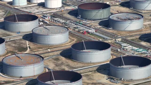 Highlighting the expansive facilities of an oil refinery, this visual journey captures the intricate network of tanks and pipelines essential for crude oil processing.