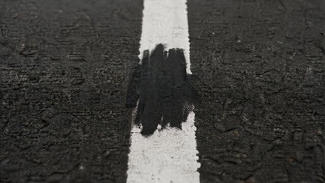 overpaint. Close-up of a white road line on asphalt, a section painted over with black. mobility guides, transit brochures, designed for mobility and urban transit guides.