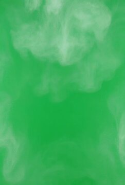 Abstract Cloud Smoke Wisps Floating Upward Against a Vibrant Green Screen Background with Subtle Glittering Particles and Soft Natural Lighting