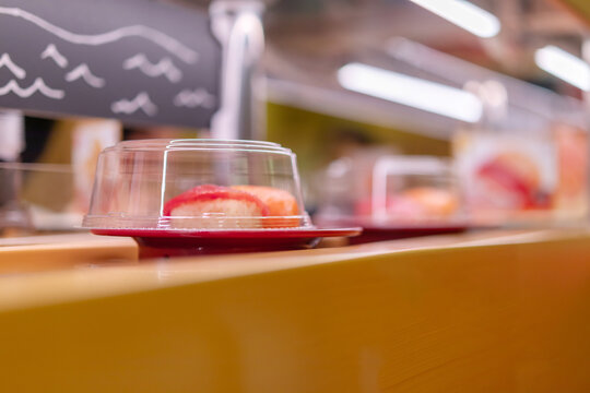 Fresh sushi on conveyor belt in Japanese kaiten sushi restaurant
