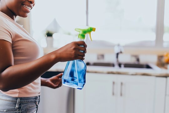 Woman holding spray bottle for home cleaning