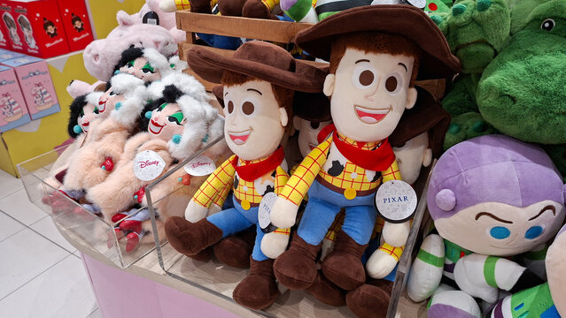 Soft plush dolls of Woody and Buzz Lightyear from Toy Story together with other Disney characters displayed on a shelf on May 8, 2026 in Bangkok, Thailand.