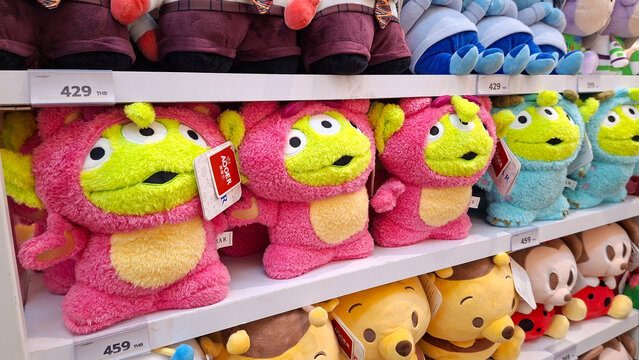 Row of cute Disney Pixar Green Men plush toys wearing Lotso and Sally costumes displayed on retail shelf on May 6, 2026 in Bangkok, Thailand.