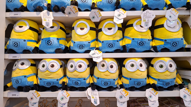 Large collection of classic Minions plush toys with goggle eyes and blue overalls arranged on retail store display shelves on May 6, 2026 in Bangkok, Thailand. 