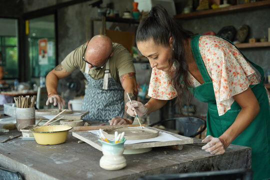 A happy couple makes ceramic plates in a workshop