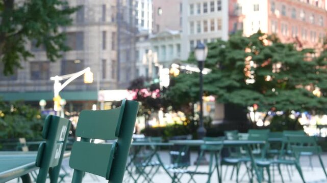 Fifth 5 avenue and Broadway street crossroad, Manhattan Midtown, New York City, United States. Defocused people pedestrians, chairs and tables for picnic in Madison Square Park, Flatiron District .