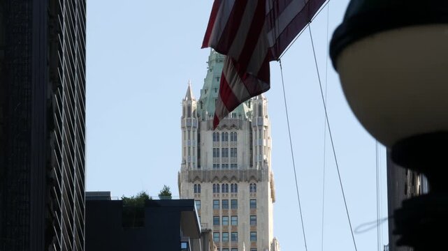 New York City Woolworth building 1913, skyscraper on Broadway in Downtown Financial District, Lower Manhattan, United States of America. Gothic historic architecture, cooper roof, USA american flag.