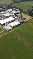 Obraz premium Industrial Landscape: An aerial perspective reveals an industrial complex nestled amidst verdant fields, a harmonious blend of manufacturing and natural surroundings.