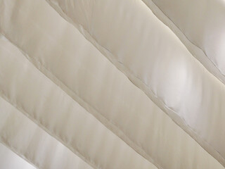 Fototapeta premium Close Up View of Cream Colored Quilted Fabric with Diagonal Stitching and Soft Texture