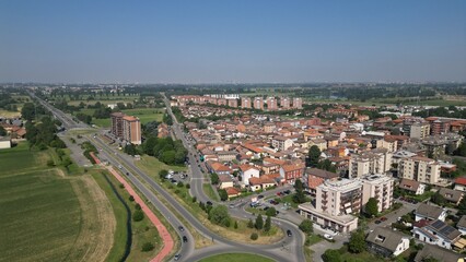Fototapeta premium Urban Panorama: An expansive aerial view of a bustling cityscape under a clear blue sky. The scene showcases a tapestry of architectural designs and city planning. Pantigliate, Milan, Italy