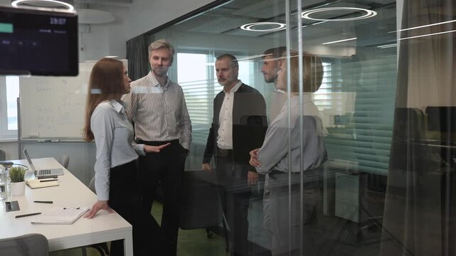 Creative business people, planning and meeting and brainstorming, ideas or strategy at office, view from glass wall.