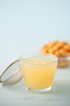 Composition with glass of aquafaba and chickpeas on blue table. Vegan meals  concept