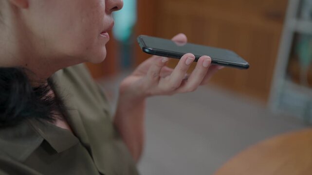 Voice Recording on Phone A woman's focused expression as she records a voice message, utilizing her smartphone.