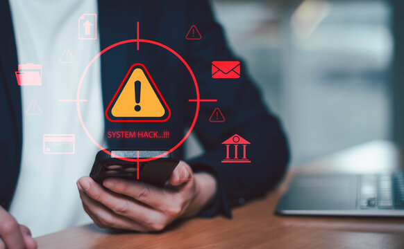 Business professional using laptop with holographic cyberattack warning and system hack alert interface. Concept of cybersecurity threat, data breach, ransomware attack, online fraud.
