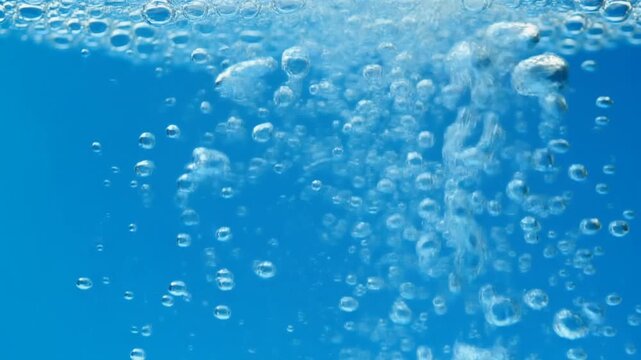 青い水の中で無数の泡が上昇する爽やかで清潔感のある動画