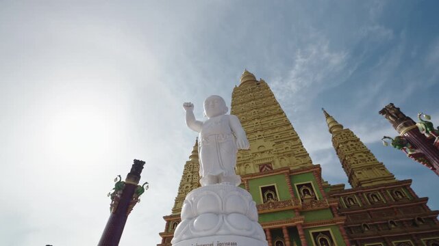 Cinematic Orbit Shot Around White Baby Buddha Statue on Lotus Pedestal, Revealing the Golden Mahabodhi Pagoda of Wat Bang Thong, Krabi, Thailand, 4k Stock Video