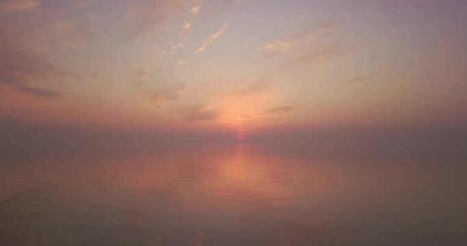 Flying over the sea during sunset, beautiful orange sunset