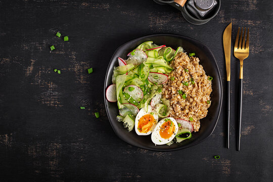 Healthy Breakfast Bowl with Oatmeal Salad and Soft Boiled Eggs. Top view