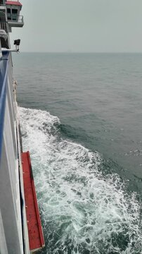 Vertical Shot of Ferry Boat Side Crossing the Ocean with White Sea Foam