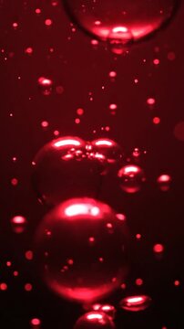 Abstract red bubbles ascending in dark fluid visual concept