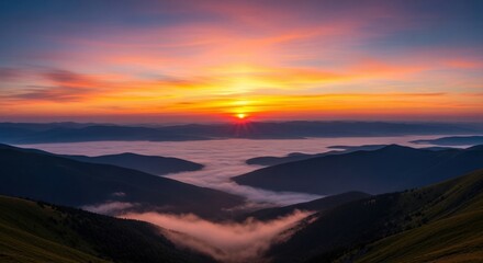 Fototapeta premium Vibrant sunset over misty mountain ranges with orange sky landscape