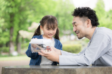 虫を観察する親子(父娘)2人のポートレート、自然体験と昆虫採集などの生物の学びの教育　夏休みの自由研究や体験学習のイメージ © kapinon