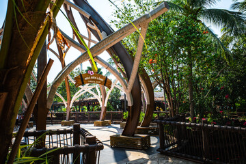 Decorative archway with rope design at the entrance of Lantern House in a tropical theme park. © garcon daily photo