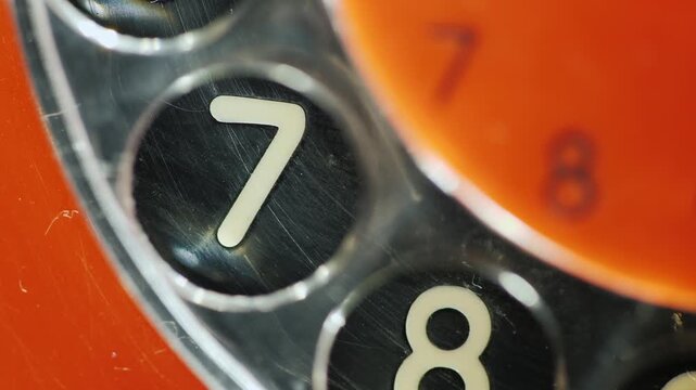 Extreme close up of vintage rotary phone dial with number 7 button.