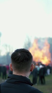 Man standing with burning bonfire in background during spring festival near Liberec Czech Republic Europe