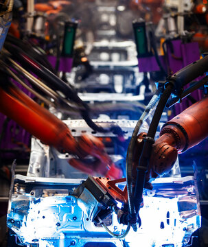 Robotic arms are welding on an automated car production line.