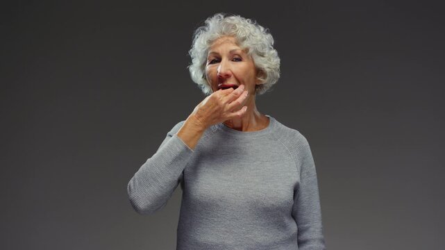 Old female hand holds in fingers capsule of Omega 3. Senior elderly woman eat yellow pill, use. Grandmother take fish oil capsule or medicine and puts it in mouth. Dietary supplements in nutrition