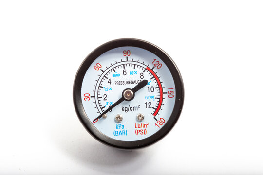 Close-up of a professional black analog pressure gauge with white dial displaying measurements in kg/cm&sup2;, kPa (BAR), and PSI (Lb/in&sup2;). The needle points to approximately 9 kg/cm&sup2;. Essential industrial