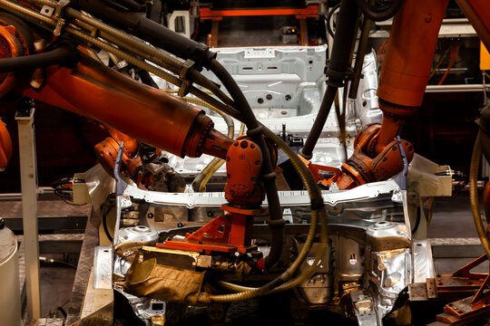 Robotic arms are welding on an automated car production line.