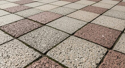 Fototapeta premium Close-up view of a rough, unpolished stone floor pattern with alternating tile colors and textures.