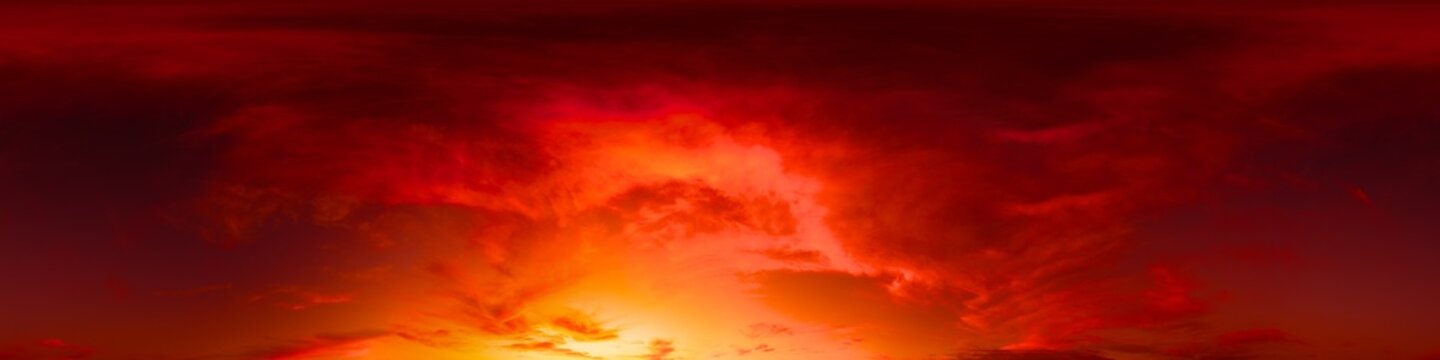 Sunset sky panorama showing dramatic fiery red and orange clouds across a wide horizon with copy space