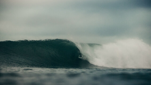 surfer and wave in stormy seas 