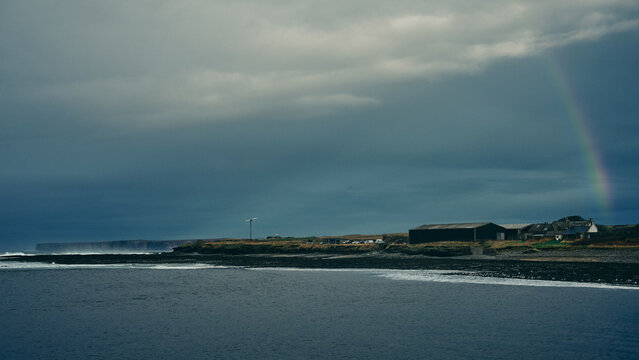 rainbow over the river and town by rivermouth in stormy weather