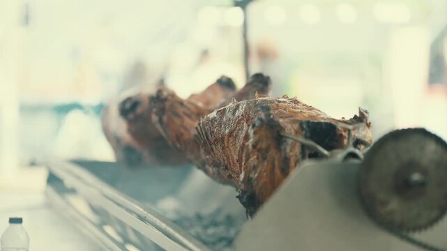 Cooking a whole pig on a spit at an outdoor event in the afternoon sun with friends and family enjoying the meal