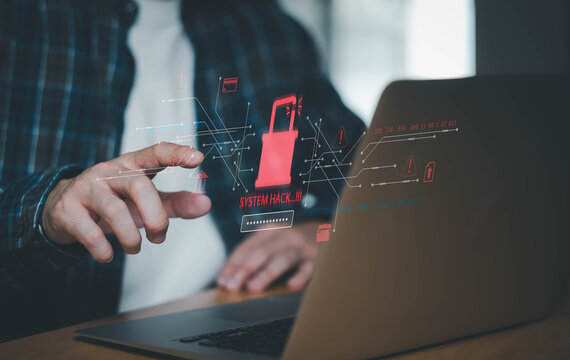 : Business professional using laptop with holographic cyberattack warning and system hack alert interface. Concept of cybersecurity threat, data breach, ransomware attack, online fraud.