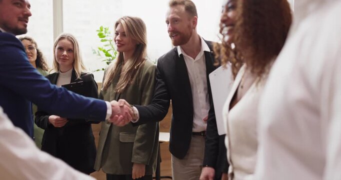 Handshake agreement partners business people meeting. Closeup of professionals sealing a deal as colleagues watch. Scene shows trust and cooperation. Clear concept of partnership success.