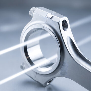 Polished aluminum connecting rod big end close-up on studio background