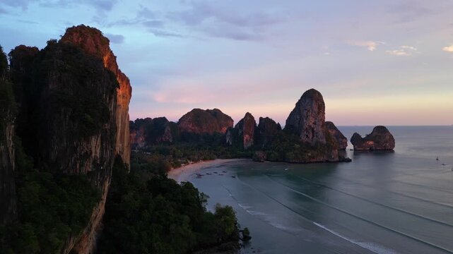 Railay beach, Thailand: Aerial forward drone footage of the dramatic limestone landscape and Railay, or Raliey beach in Krabi in Thailand by the Andaman sea. 